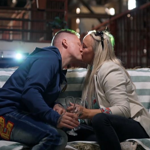 Chris og Kimi kysser på den hjemmelavede hø-divan på filmdate i stalden.