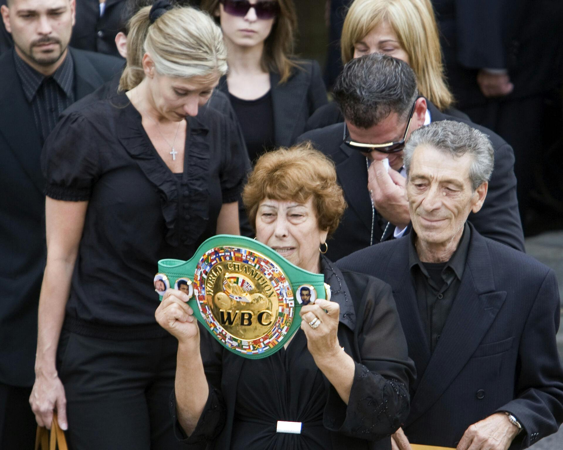 Arturo Gatti's mother Ida, holds his Championship belt as she leaves the church with his step-father, Geraldo Di Francesco and family members after funeral services for the former world champion boxer in Montreal Monday, July 20, 2009. Gatti was found dead a just over a week ago in the apartment he was renting with his wife Amanda Rodrigues in a Brazilian seaside resort. (AP Photo/The Canadian Press, Ryan Remiorz)