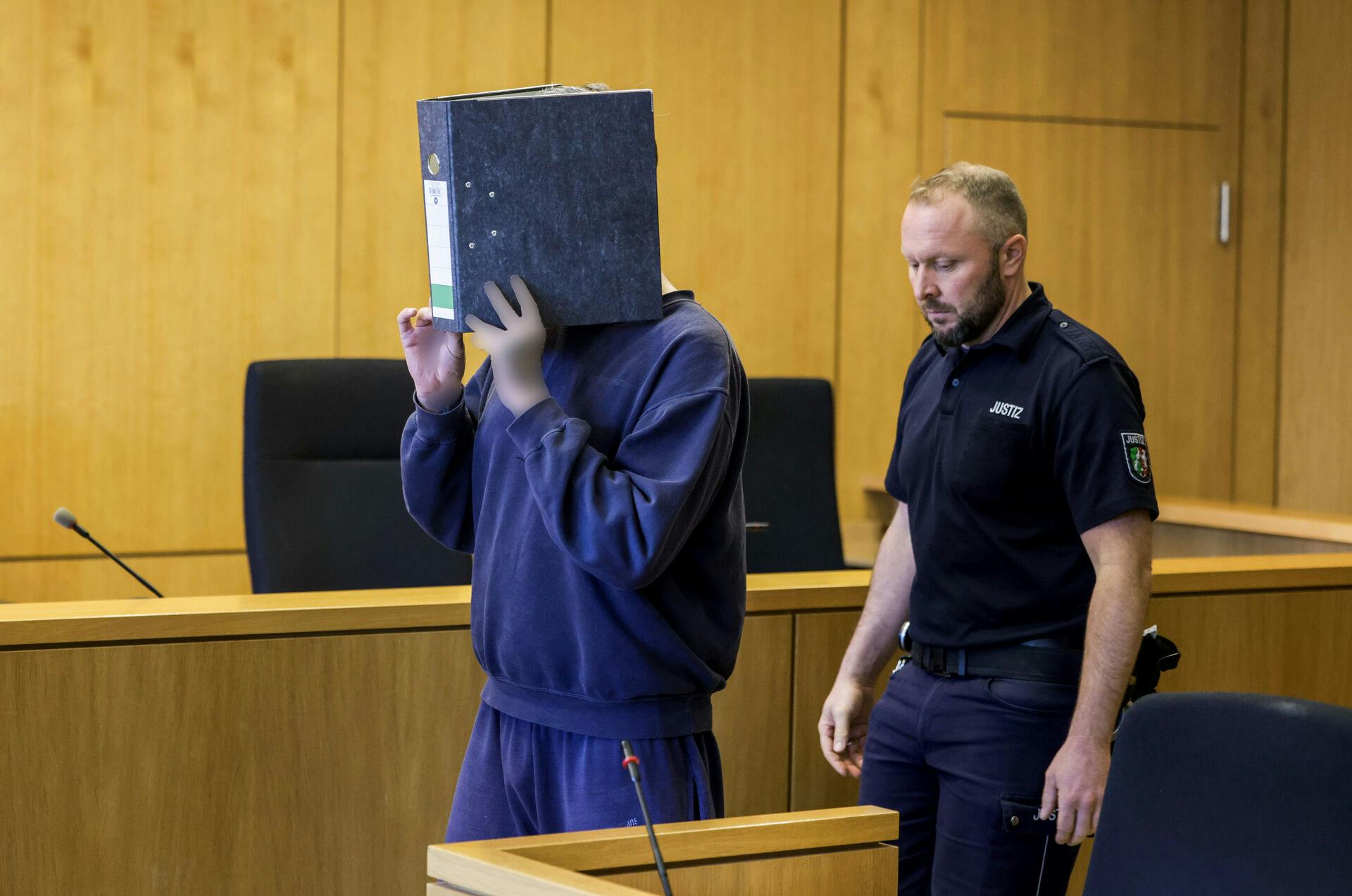 Den tiltalte sygeplejerske gemte sit ansigt, da han mødte op i retten i Aachen onsdag. Han blev idømt fængsel på livstid for drab på mindst ti patienter mellem 2023 og 2024.