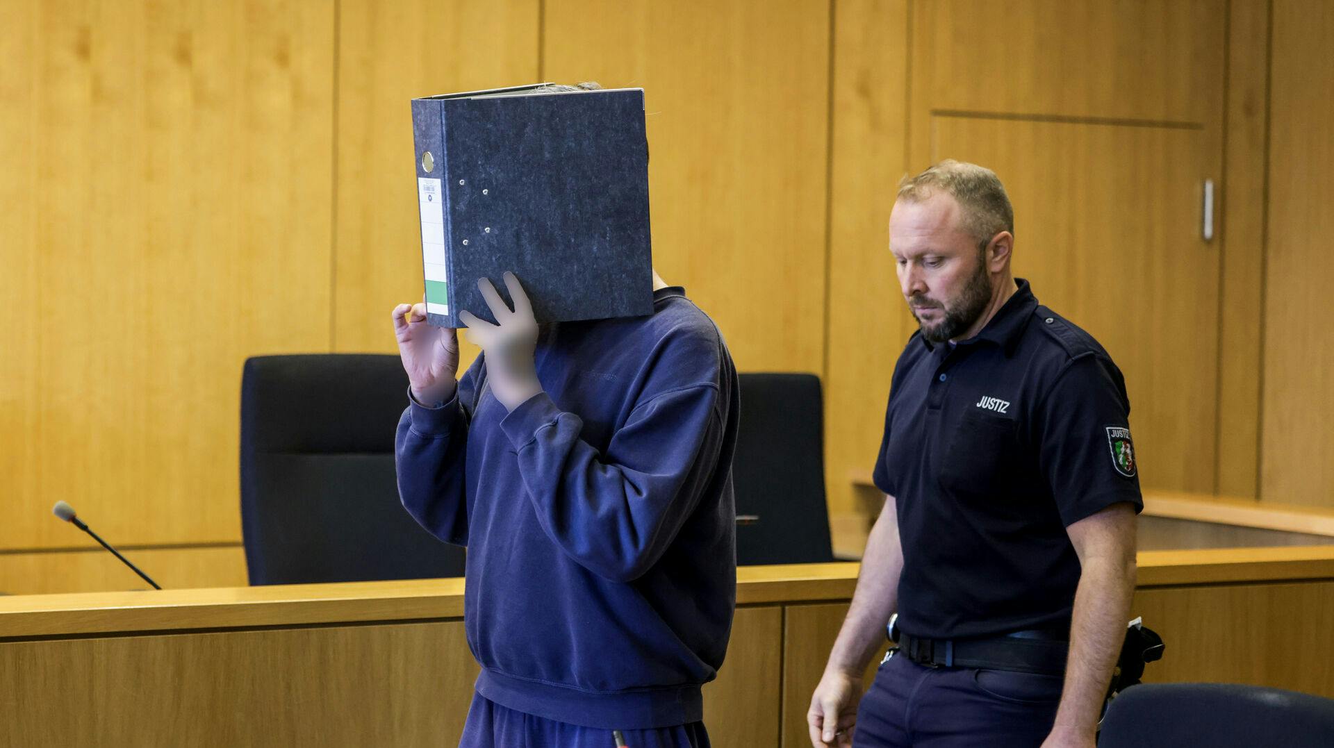 Den tiltalte sygeplejerske gemte sit ansigt, da han mødte op i retten i Aachen onsdag. Han blev idømt fængsel på livstid for drab på mindst ti patienter mellem 2023 og 2024.