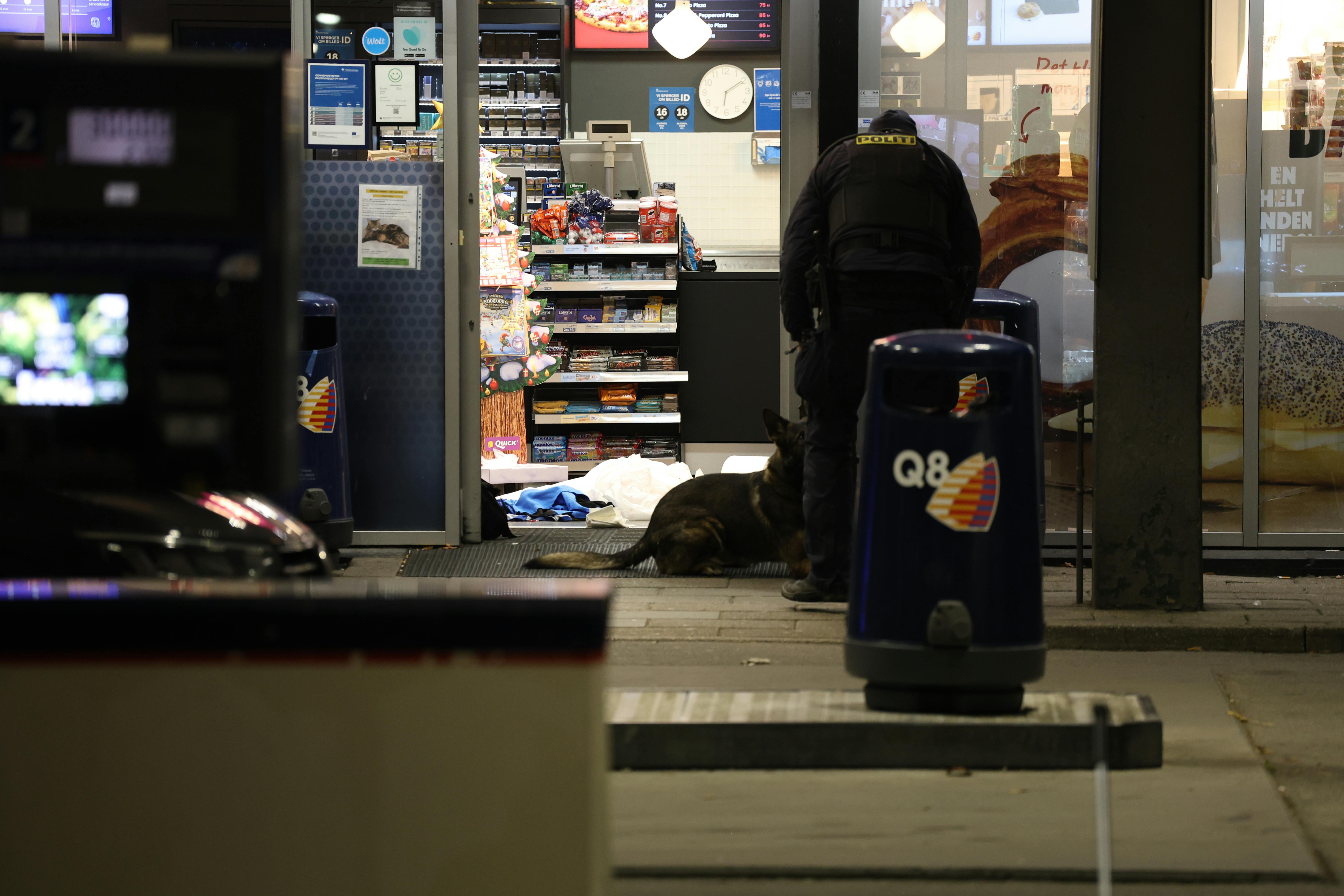 Politiets teknikere i døråbningen til Q8, hvor den 31-årige mand blev skudt og dræbt.