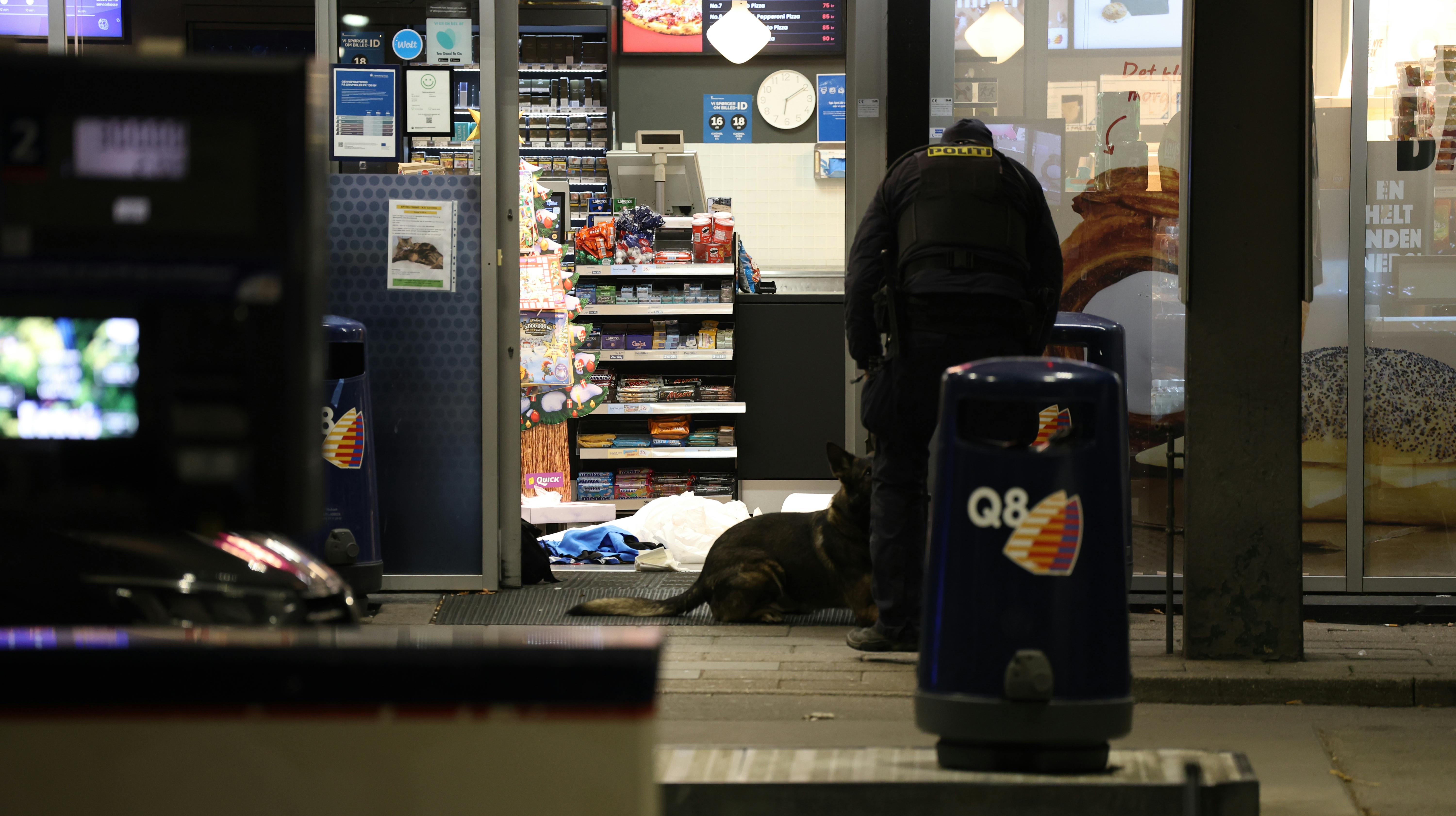Politiets teknikere i døråbningen til Q8, hvor den 31-årige mand blev skudt og dræbt.