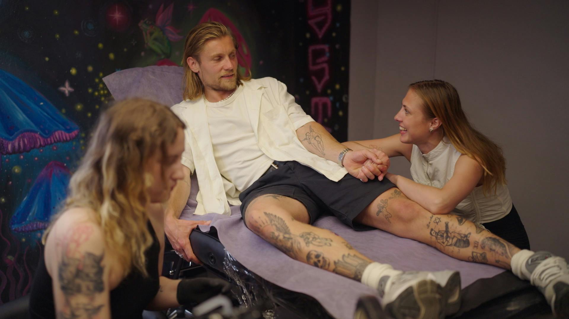 Christian Ulrik Hansen får Yin og Yang-symbolet tatoveret på benet, og hans date, Bianca, får det på skulderbladet.