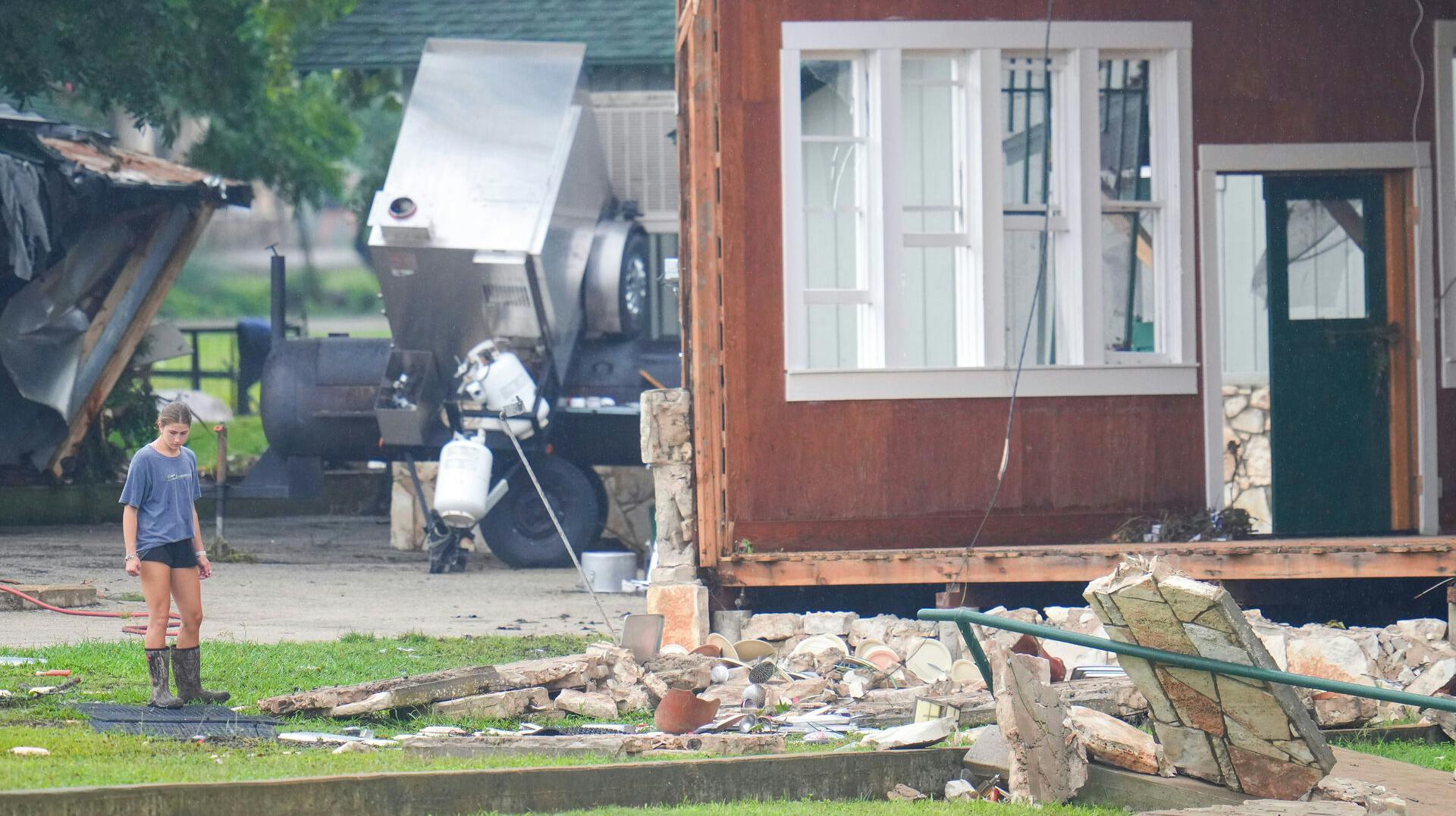 FILE - A person looks at damage to the main building at Camp Mystic along the banks of the Guadalupe River after a flash flood swept through the area, July 6, 2025, in Hunt, Texas. (AP Photo/Julio Cortez)