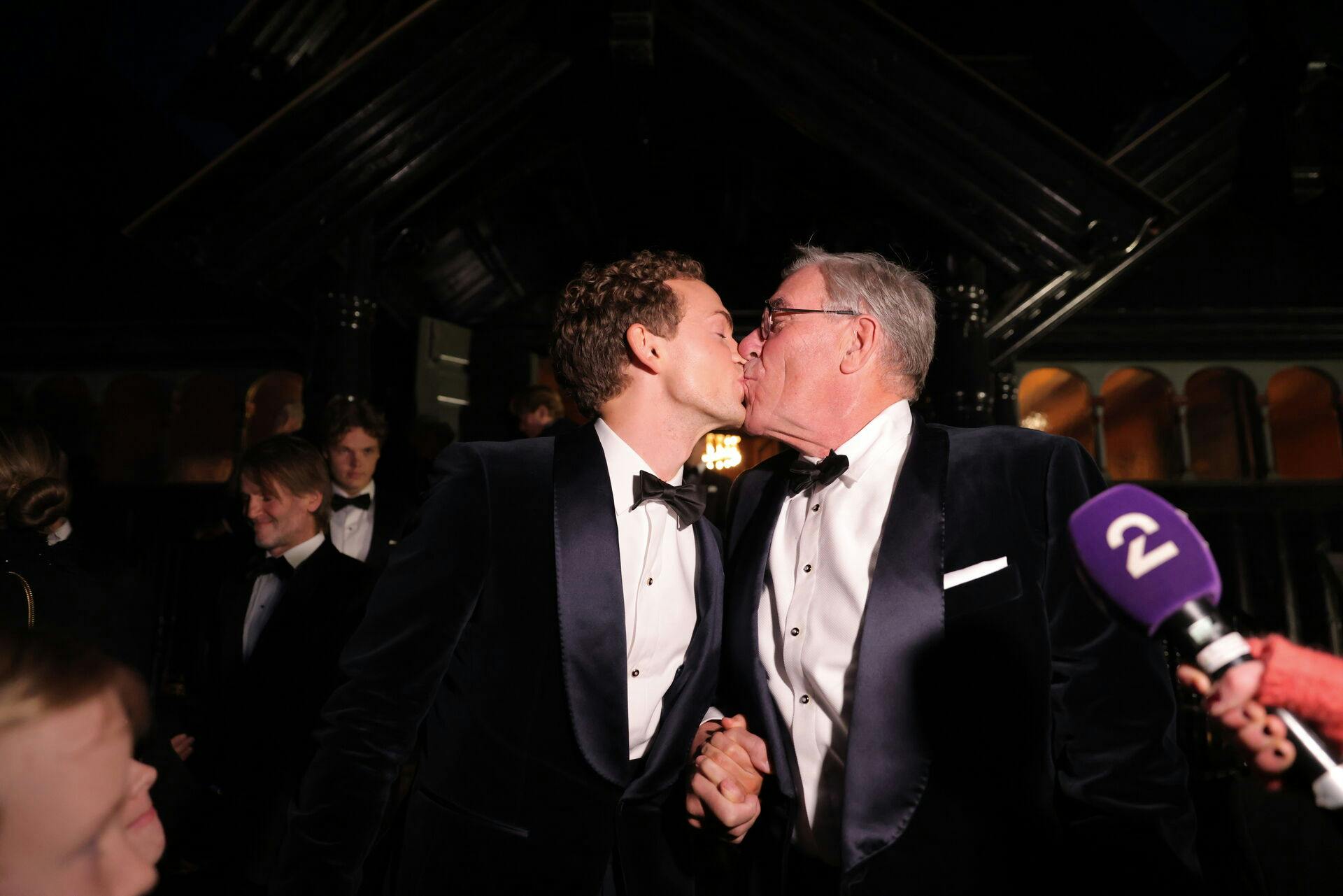 Omringet af kameraer og mikrofoner kyssede det nye ægtepar. 