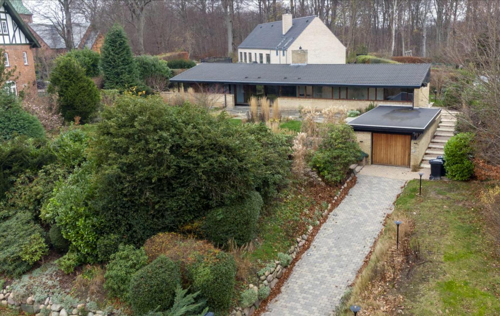 Bag Jannik Brandt Thomsens villa ligger skoven og Vedbæk kirke.