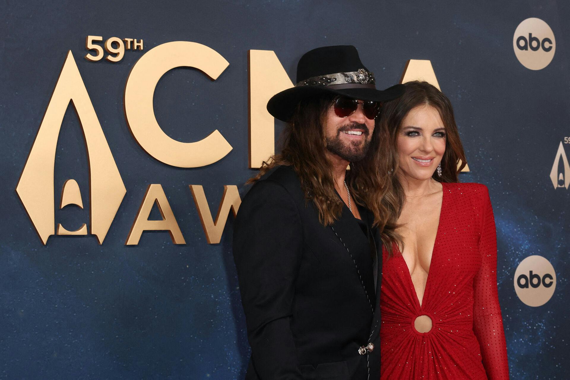 Billy Ray Cyrus and Elizabeth Hurley pose on the red carpet at the 59th Annual Country Music Association Awards in Nashville, Tennessee, U.S., November 19, 2025. REUTERS/Kylie Cooper