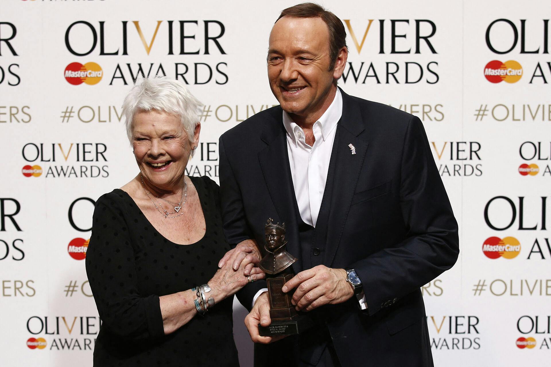 US actor, producer and director Kevin Spacey (R) poses with a special award recognising his contribution to British theatre during his tenure as Artistic Director of The Old Vic with British actress Judi Dench (L) during the Lawrence Olivier Awards for theatre at the Royal Opera House in central London on April 12, 2015. AFP PHOTO / JUSTIN TALLIS . JUSTIN TALLIS / AFP
