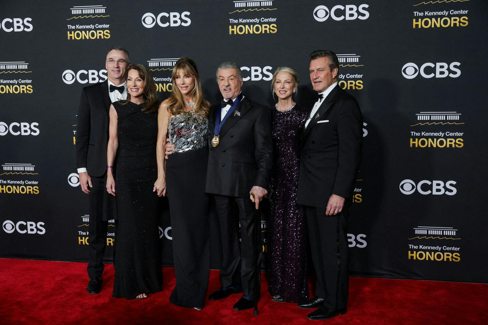 Kennedy Center Honors recipient actor Sylvester Stallone, Jennifer Flavin, Frank Stallone and other guests pose on the red carpet for the 2025 Kennedy Center Honors at the John F. Kennedy Center for the Performing Arts in Washington, D.C., U.S., December 7, 2025. REUTERS/Jeenah Moon