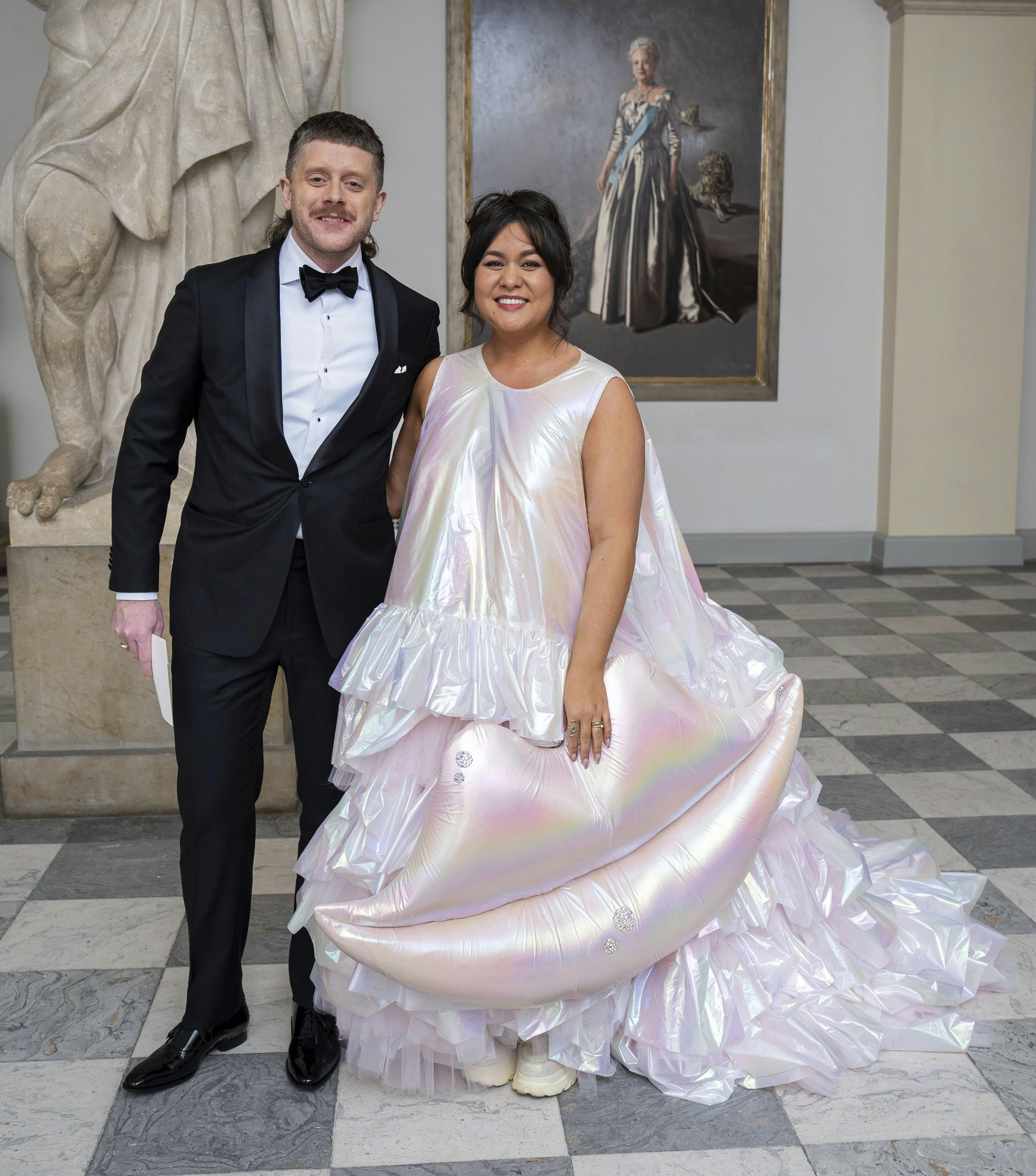 Nastasha Brock, 36, stjal showet til kongeparrets aftenselskab for kunst og kultur på Christiansborg Slot. Her ankom hun klædt i et skinnende skrud fra Nicholas Nybro. – Der var en gigantisk mund på, som, jeg syntes, passede meget godt til mit arbejde. Et lille smil. Det er jo også det, jeg håber, at jeg giver folk, sagde Natasha Brock til TV2 om kjolen, da hun ankom i selskab med manden, Albert Dieckmann.