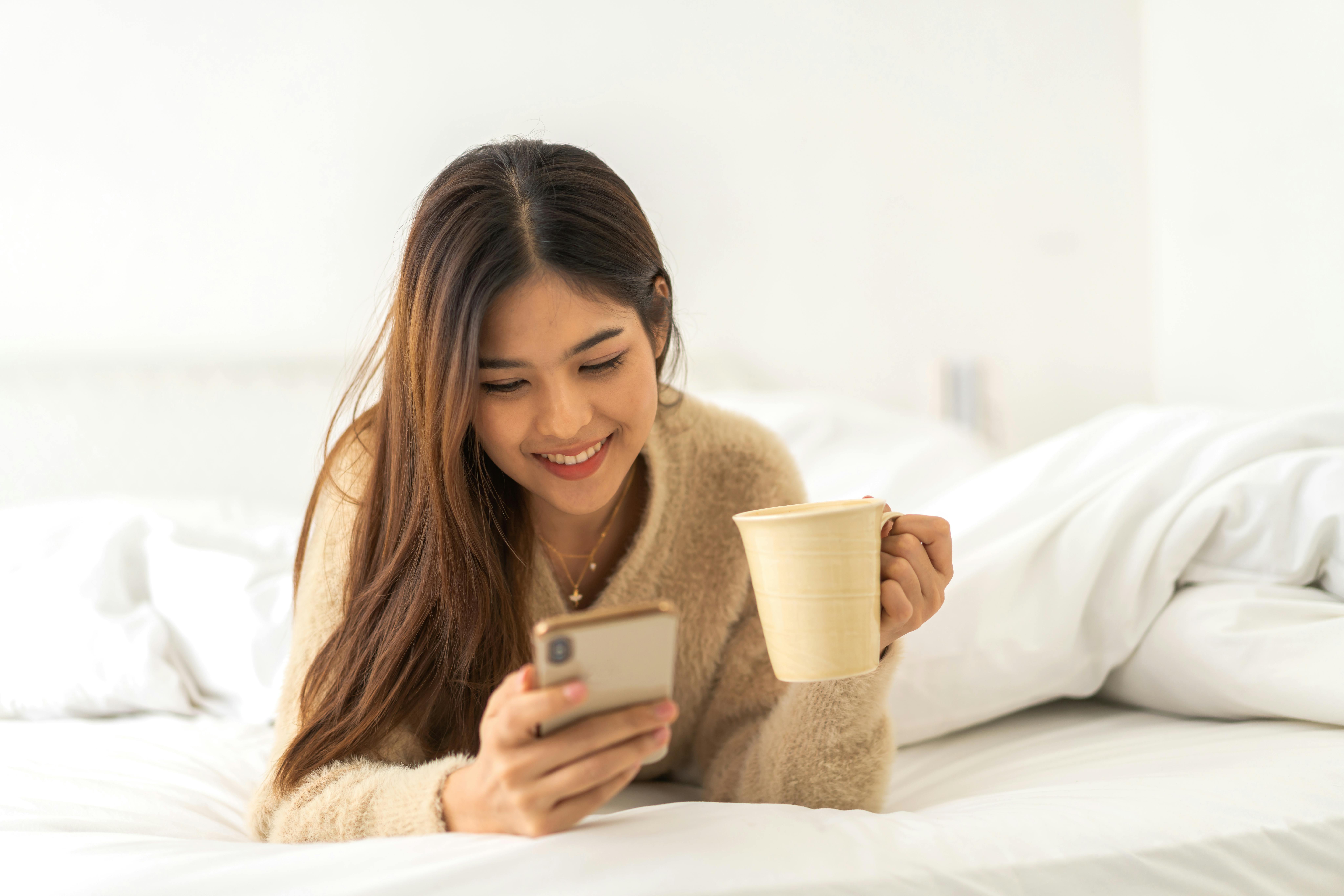 Portrait of smiling happy asian woman relax using digital smartphone.Young asian girl working or study,chatting social network and playing game online or social media,shopping online at home