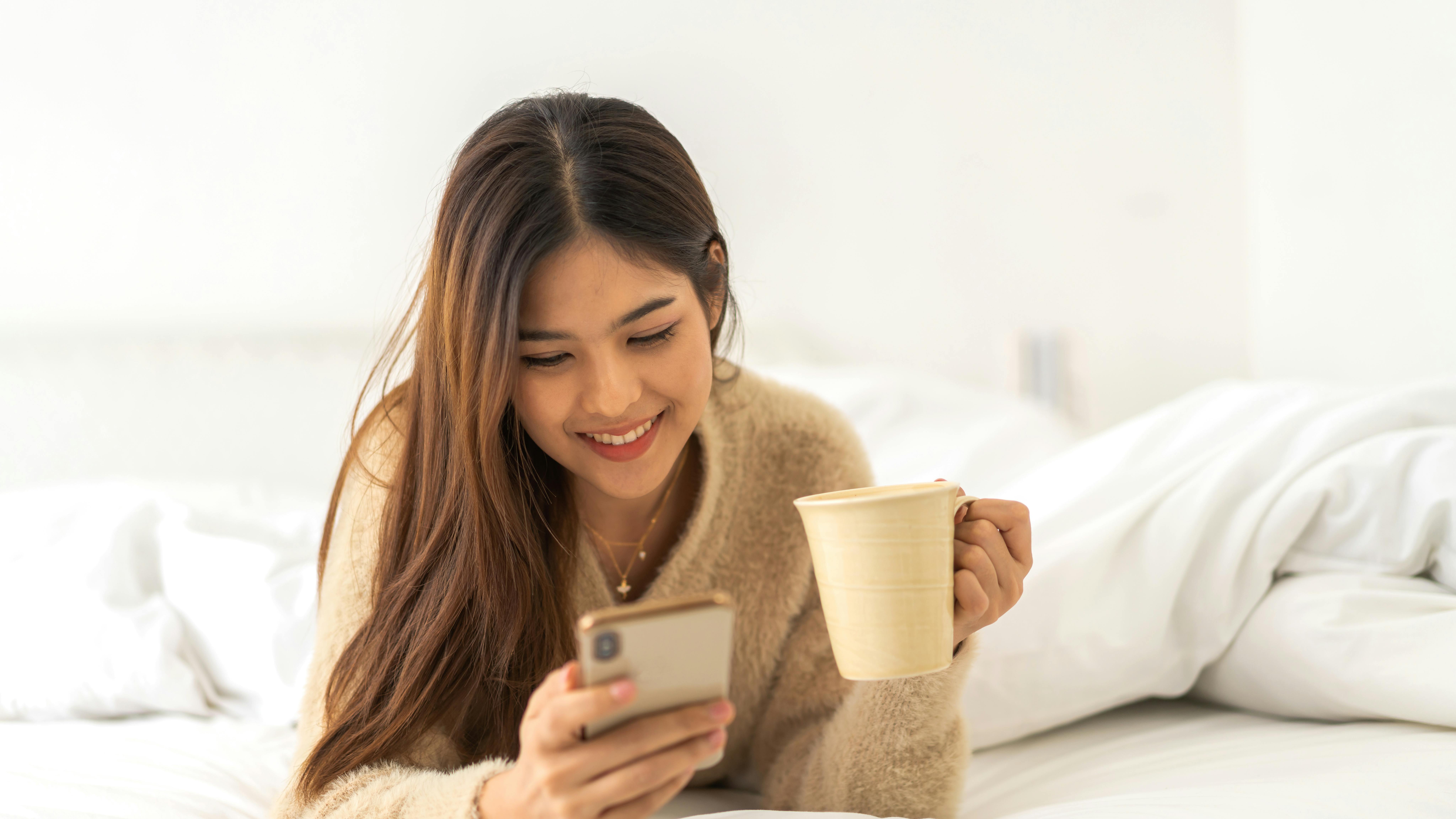 Portrait of smiling happy asian woman relax using digital smartphone.Young asian girl working or study,chatting social network and playing game online or social media,shopping online at home