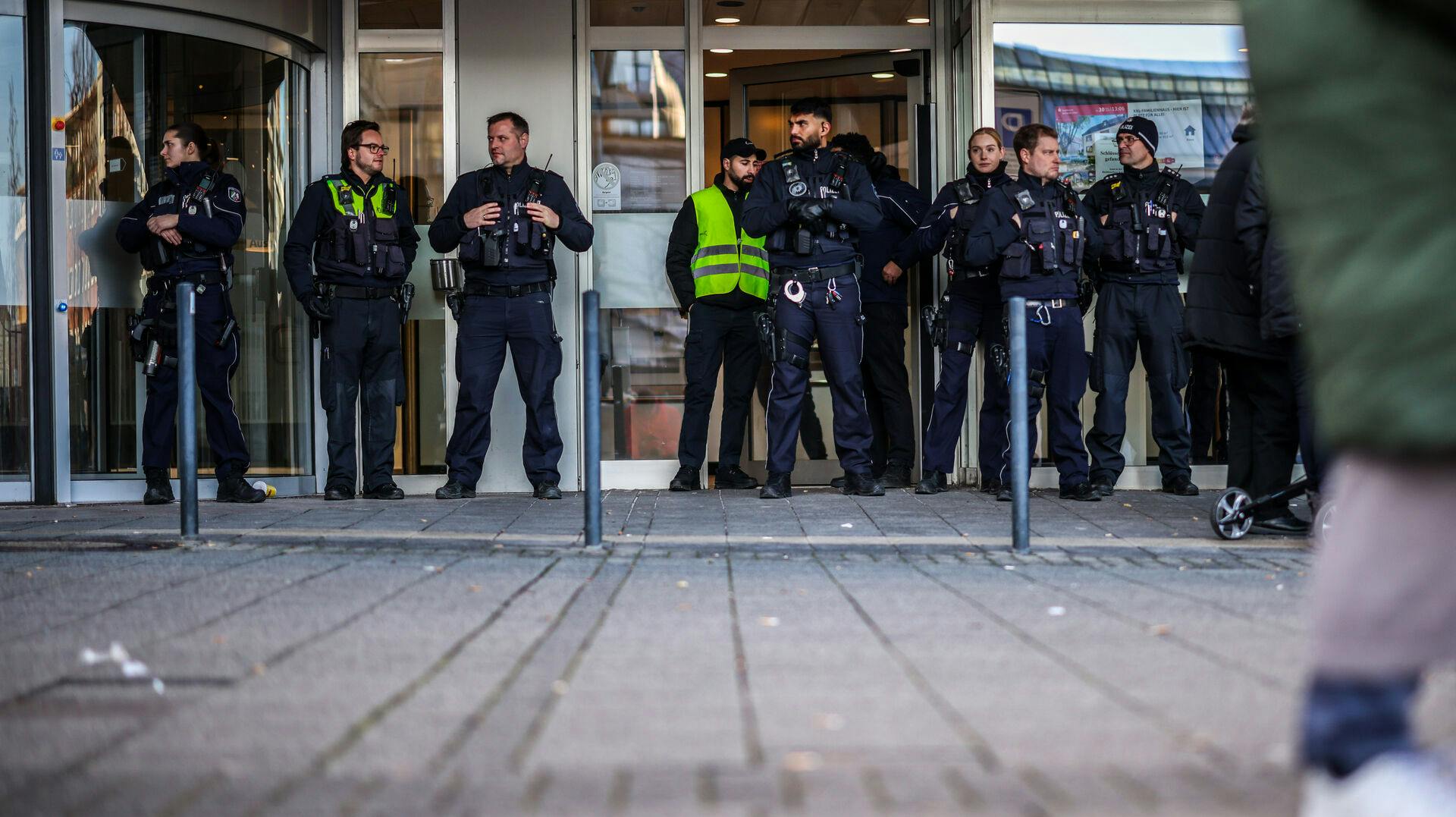 Police officers stand in front of the savings bank branch in the Buer district in Gelsenkirchen, Germany, Tuesday, Dec. 30, 2025 following a break-in into the bank's vault. (Christoph Reichwein/dpa via AP)