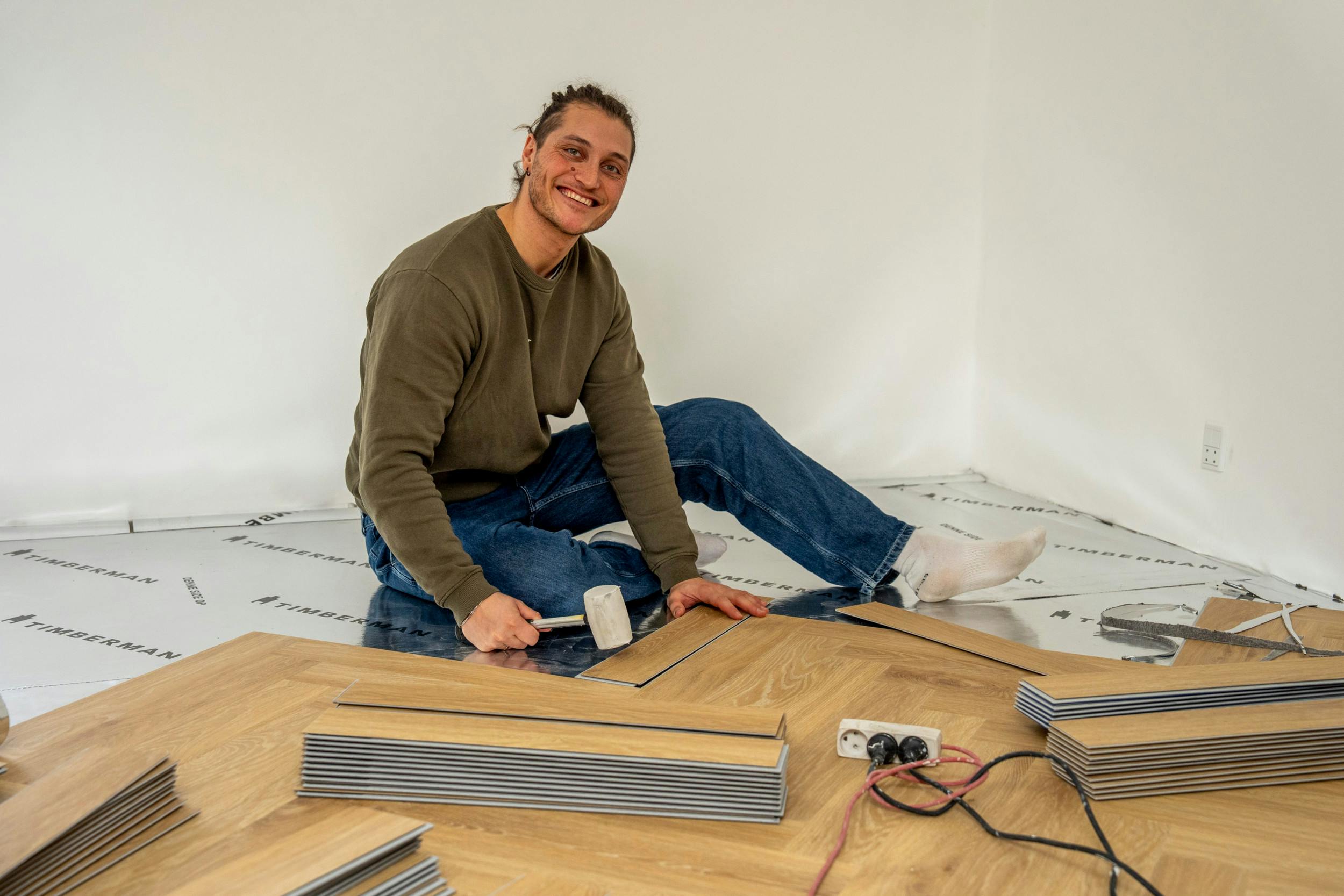 Da SE og HØR besøger parret, er det gulvet i det rum, de vil bruge som ekstra tv-stue og kontor, som Jaffer knokler med at lave færdigt.  