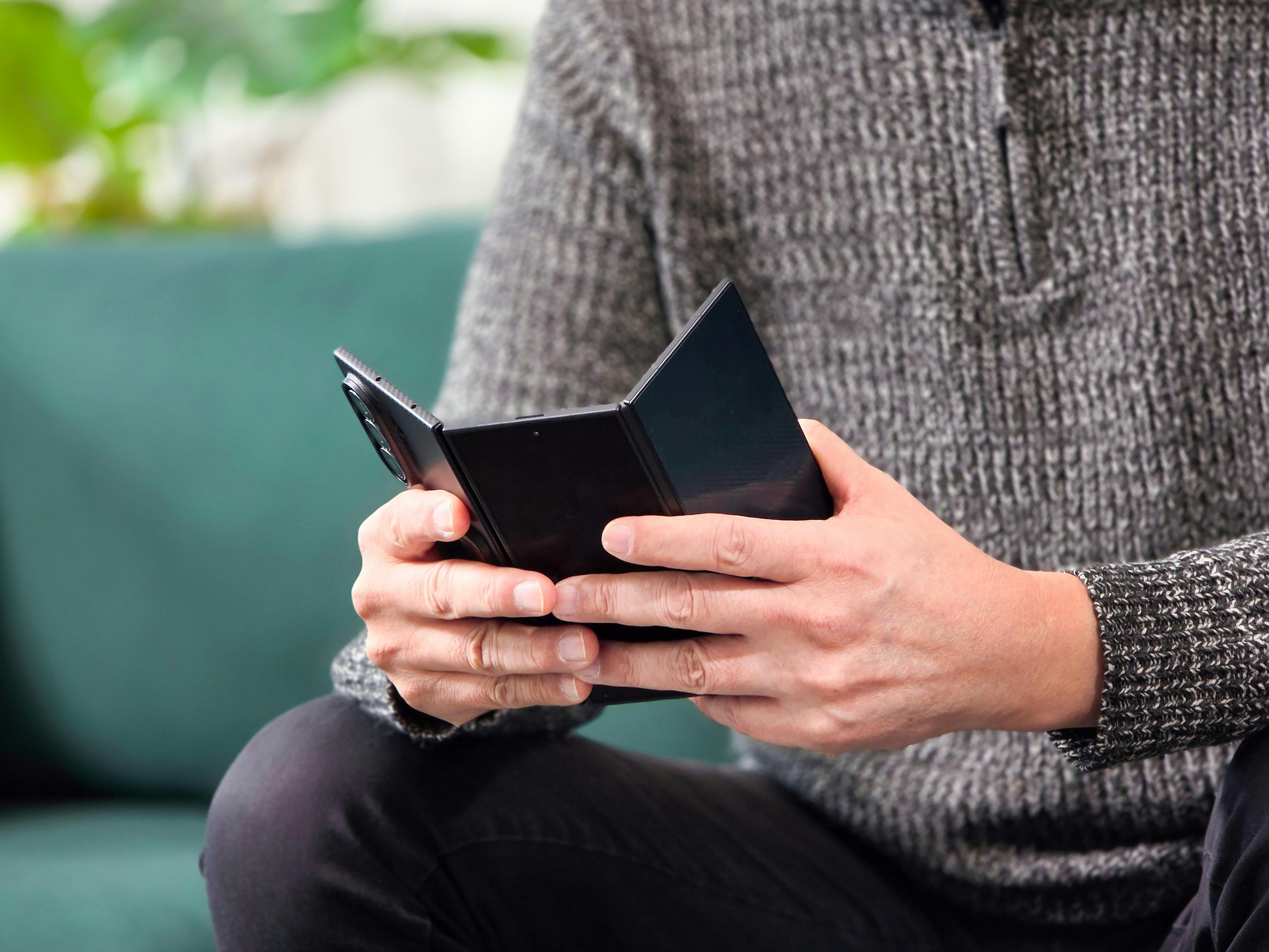 Person holder foldbar smartphone, der viser CES’ fokus på ekstreme foldetelefoner som fremtidens mobile enheder