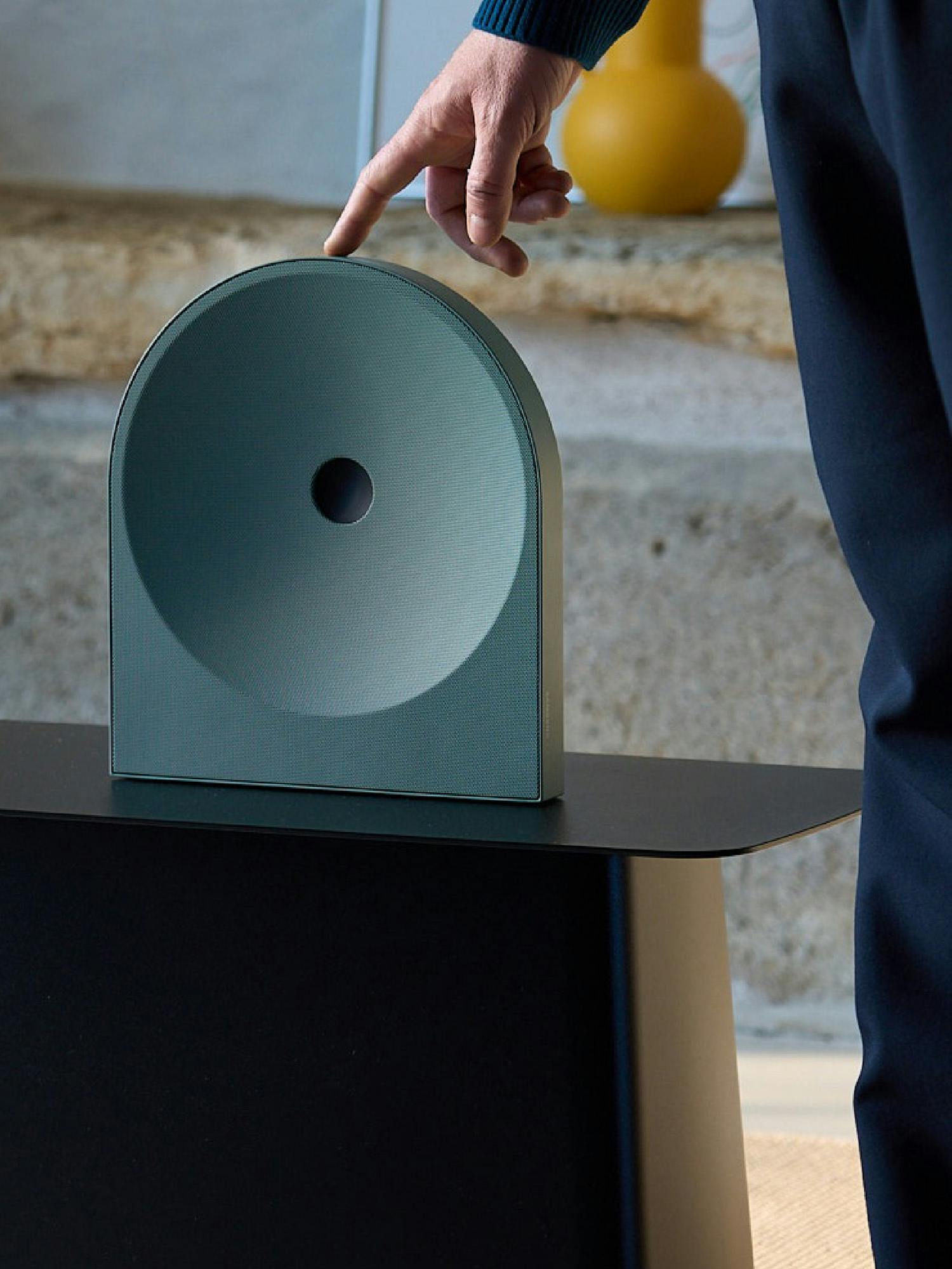 Hånd interagerer med minimalistisk smart home-enhed, der viser hvordan intelligent hjem-teknologi bliver mere enkel og brugbar