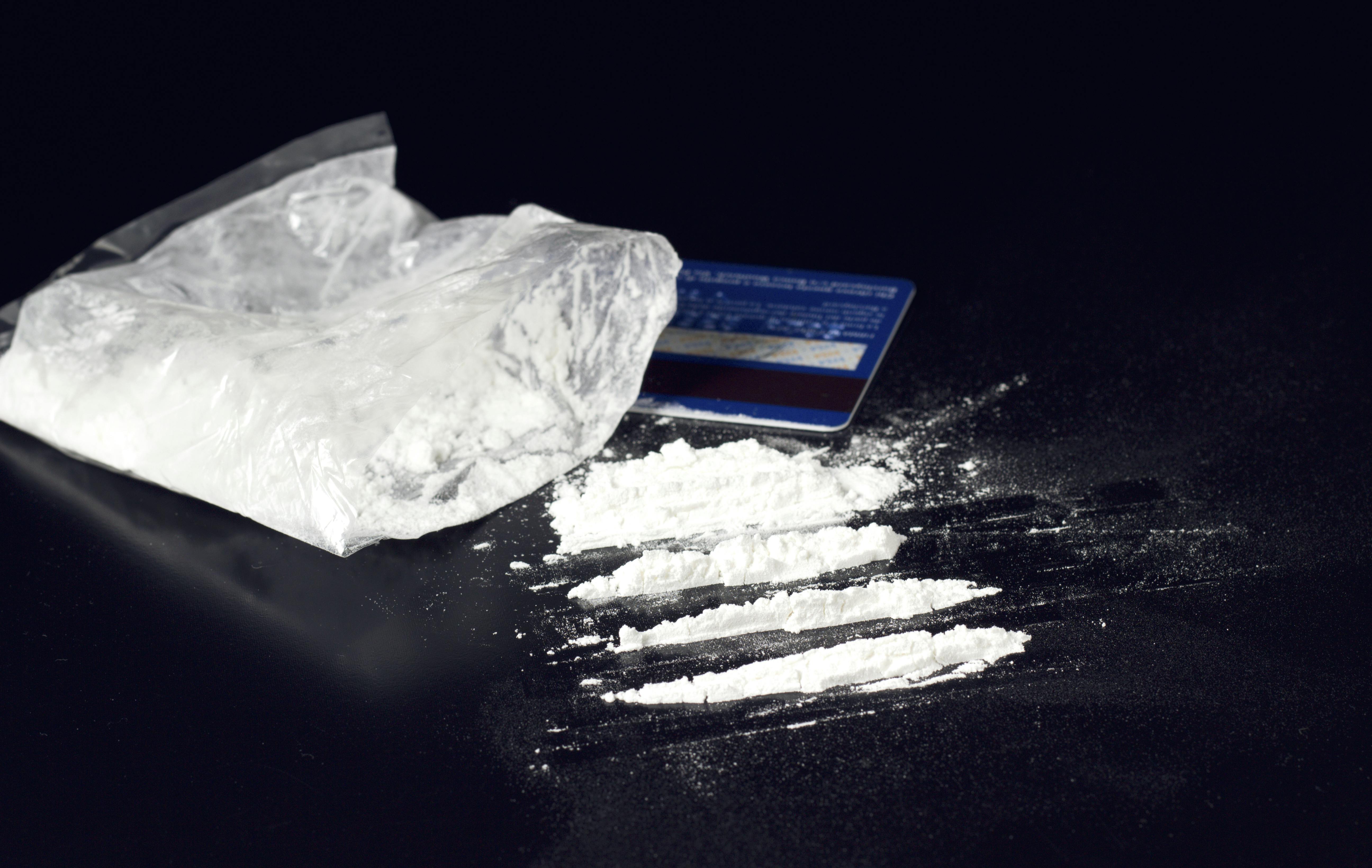 cocaine powder heap on black table with bank card