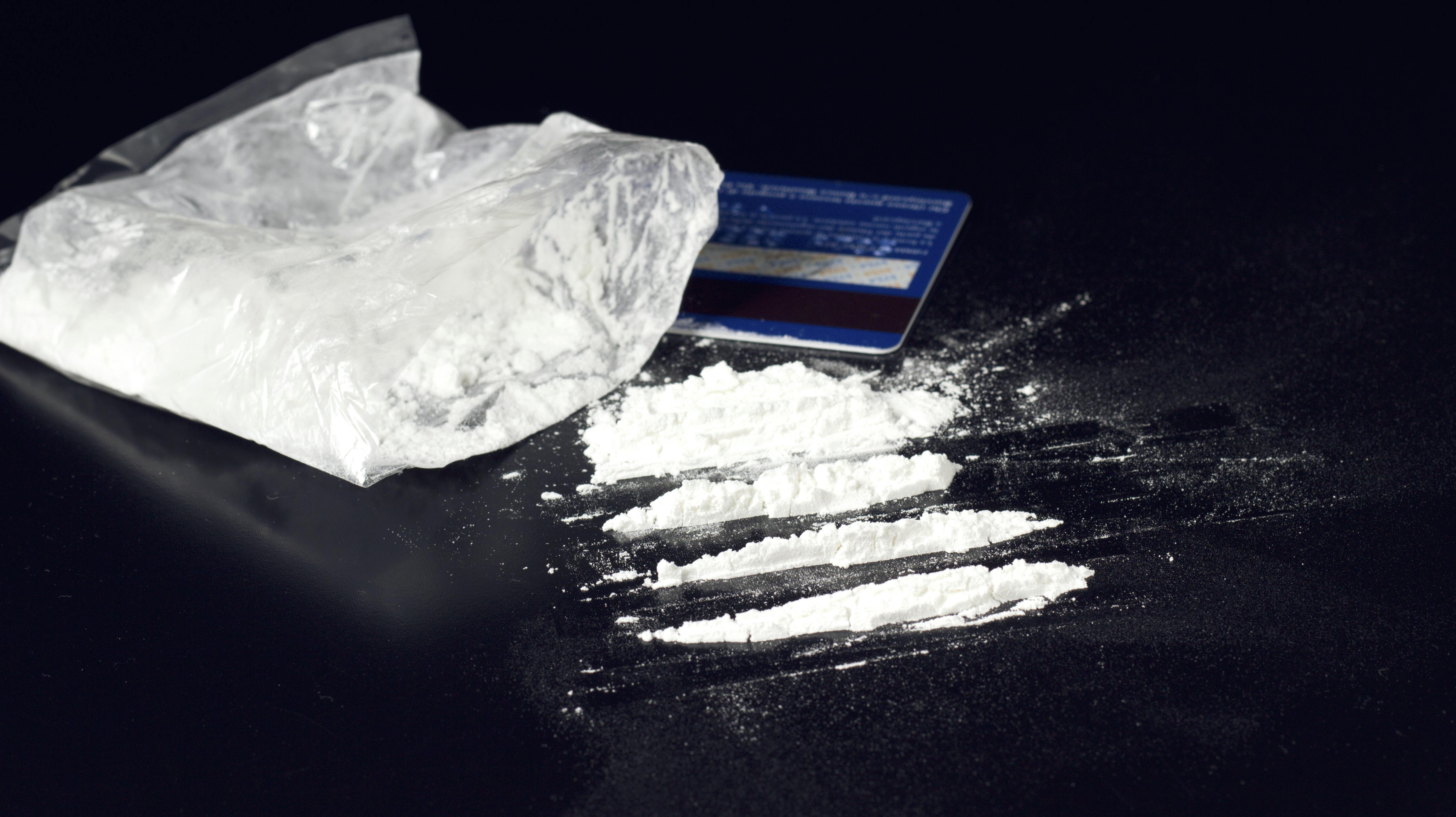 cocaine powder heap on black table with bank card