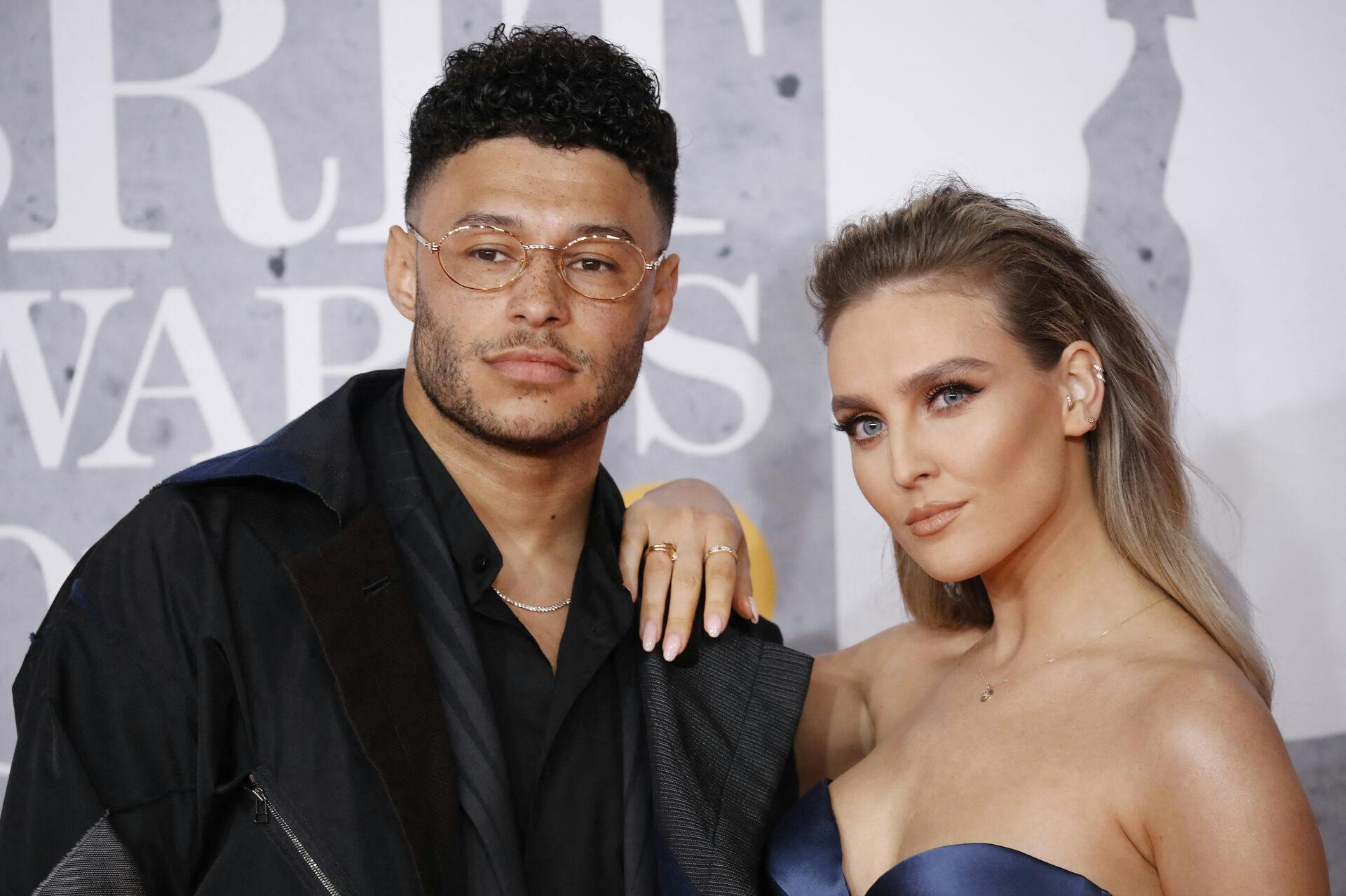 British footballer Alex Oxlade-Chamberlain and girlfriend Perrie Edwards (R) pose on the red carpet on arrival for the BRIT Awards 2019 in London on February 20, 2019. Tolga AKMEN / AFP