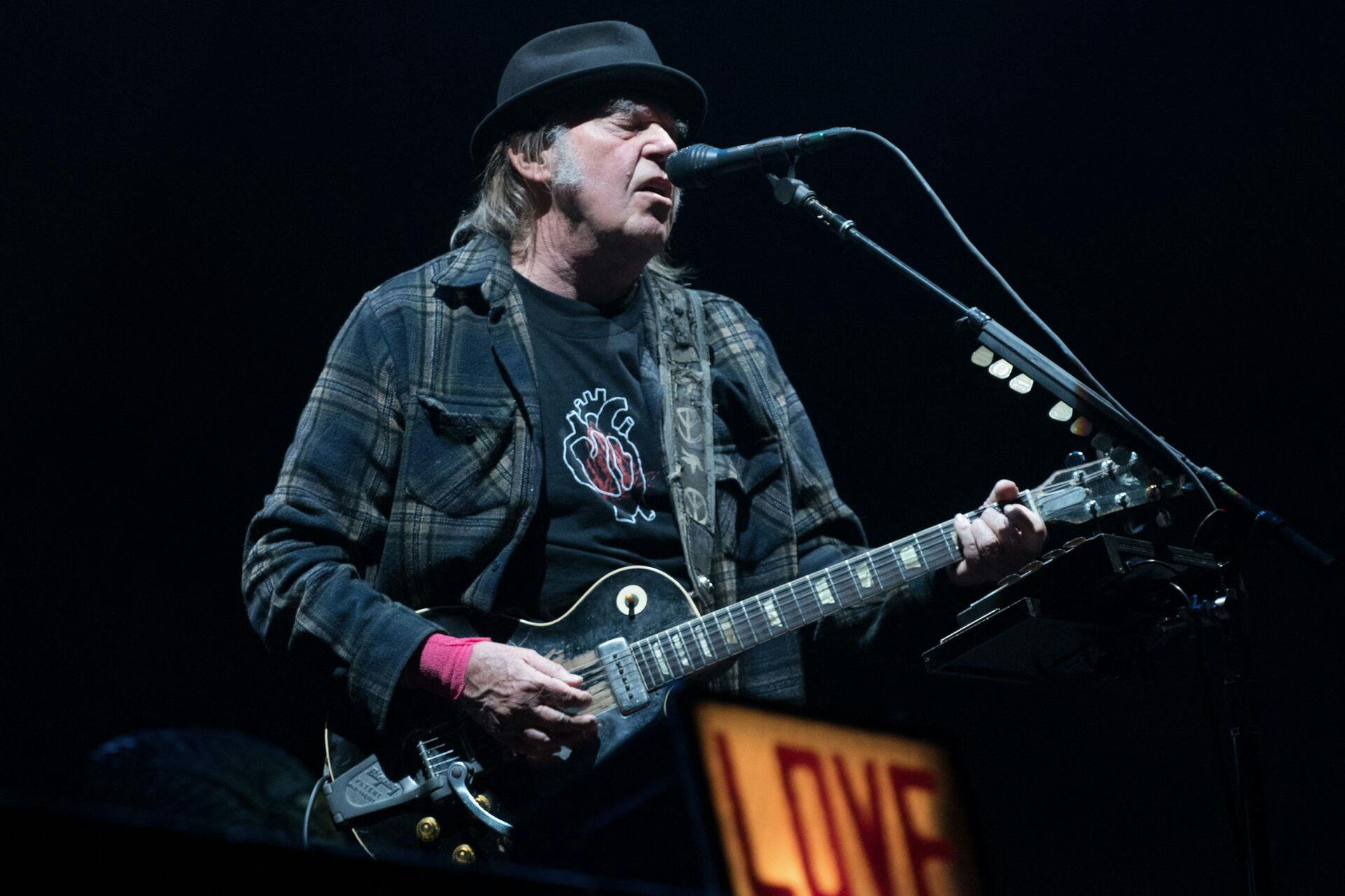 (FILES) In this file photo taken on July 7, 2018 Neil Young performs on stage for his first time in Quebec City during 2018 Festival d'Ete. - The 'Canerican' legend releases his new album entitled 'Barn', AFP reports on December 22, 2021. (Photo by Alice Chiche / AFP)