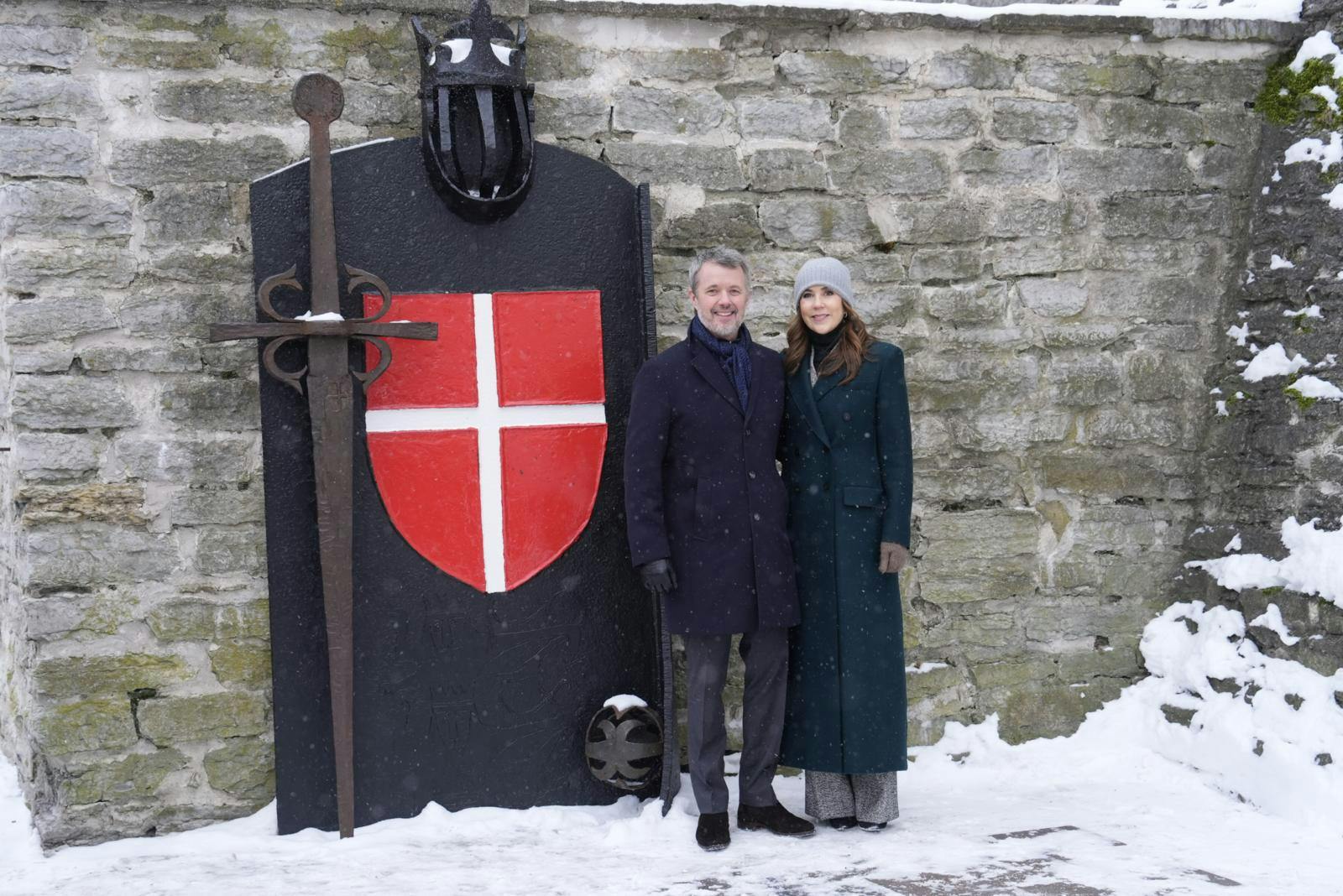 Kong Frederik og Dronning Mary er her fotograferet foran den historiske port prydet med Dannebrog i Tallinn. Besøget i Estland markerede de tætte historiske bånd, der ifølge legenden strækker sig helt tilbage til flagets fald fra himlen i 1219.