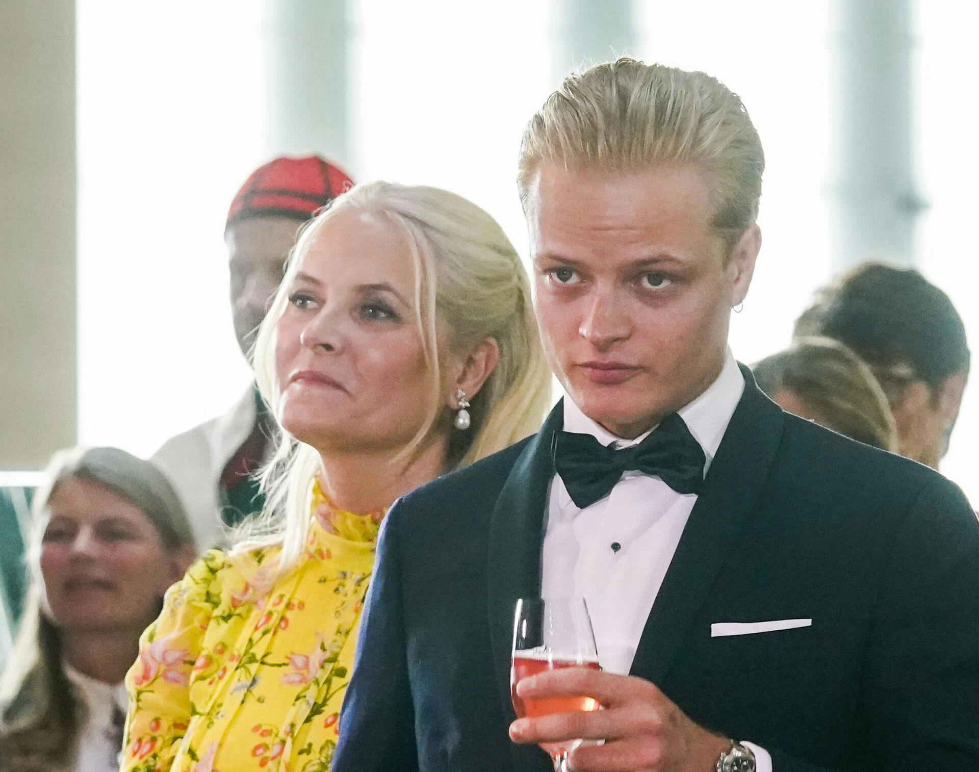 Oslo 20220616. Marius Borg Høiby og kronprinsesse Mette-Marit. Regjeringens festarrangement i forbindelse med prinsesse Ingrid Alexandras myndighetsdag holdes på Deichman Bjørvika, Oslos hovedbibliotek. Prinsessen Ingrid Alexandra fylte 18 år 21. januar 2022. Markeringene av myndighetsdagen ble utsatt til juni på grunn av smittesituasjonen og koronarestriksjonene. Bak ses prins Sverre Magnus. Foto: Lise Åserud / NTB