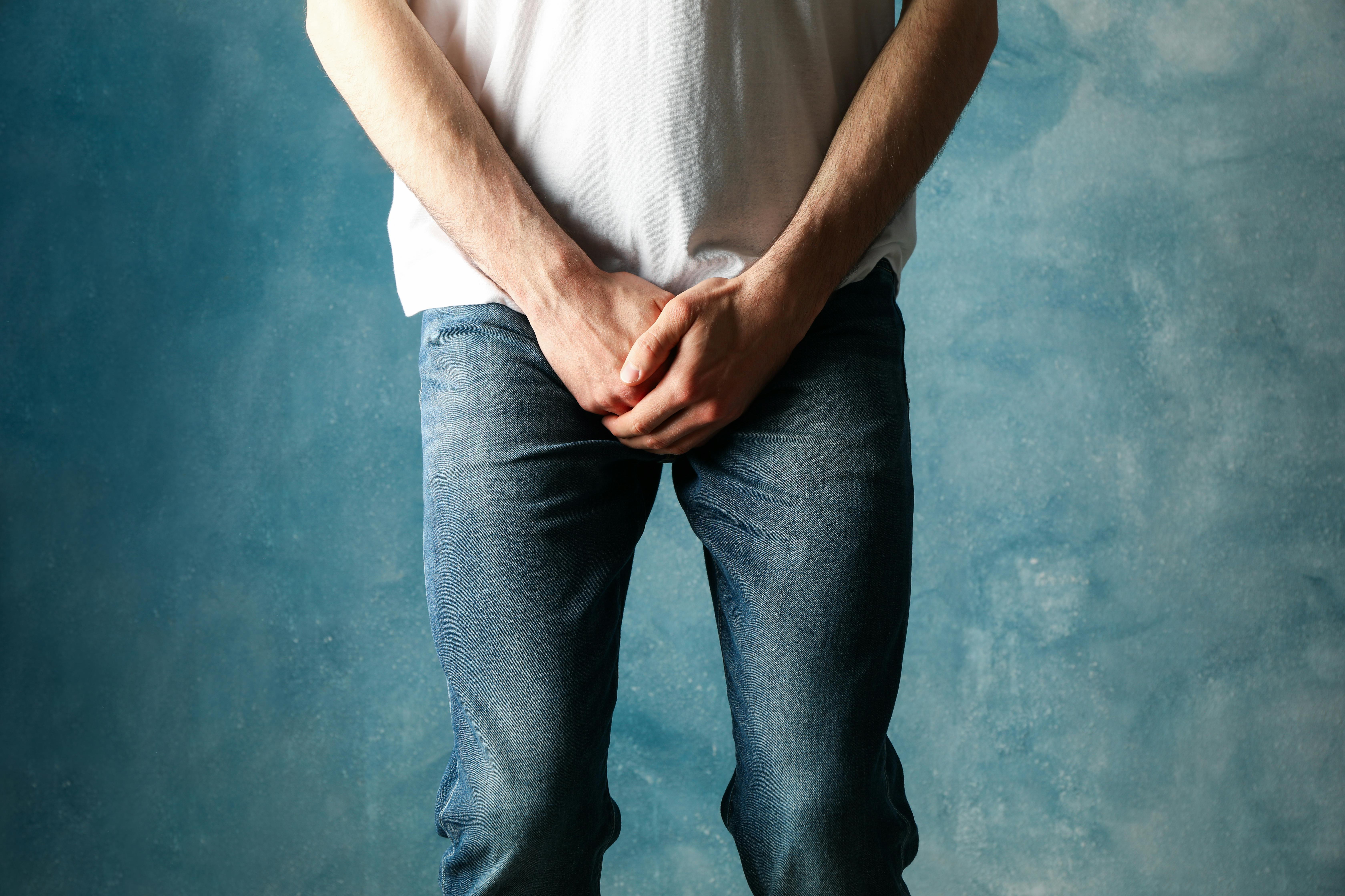 Man holds toilet paper on blue background. Urology