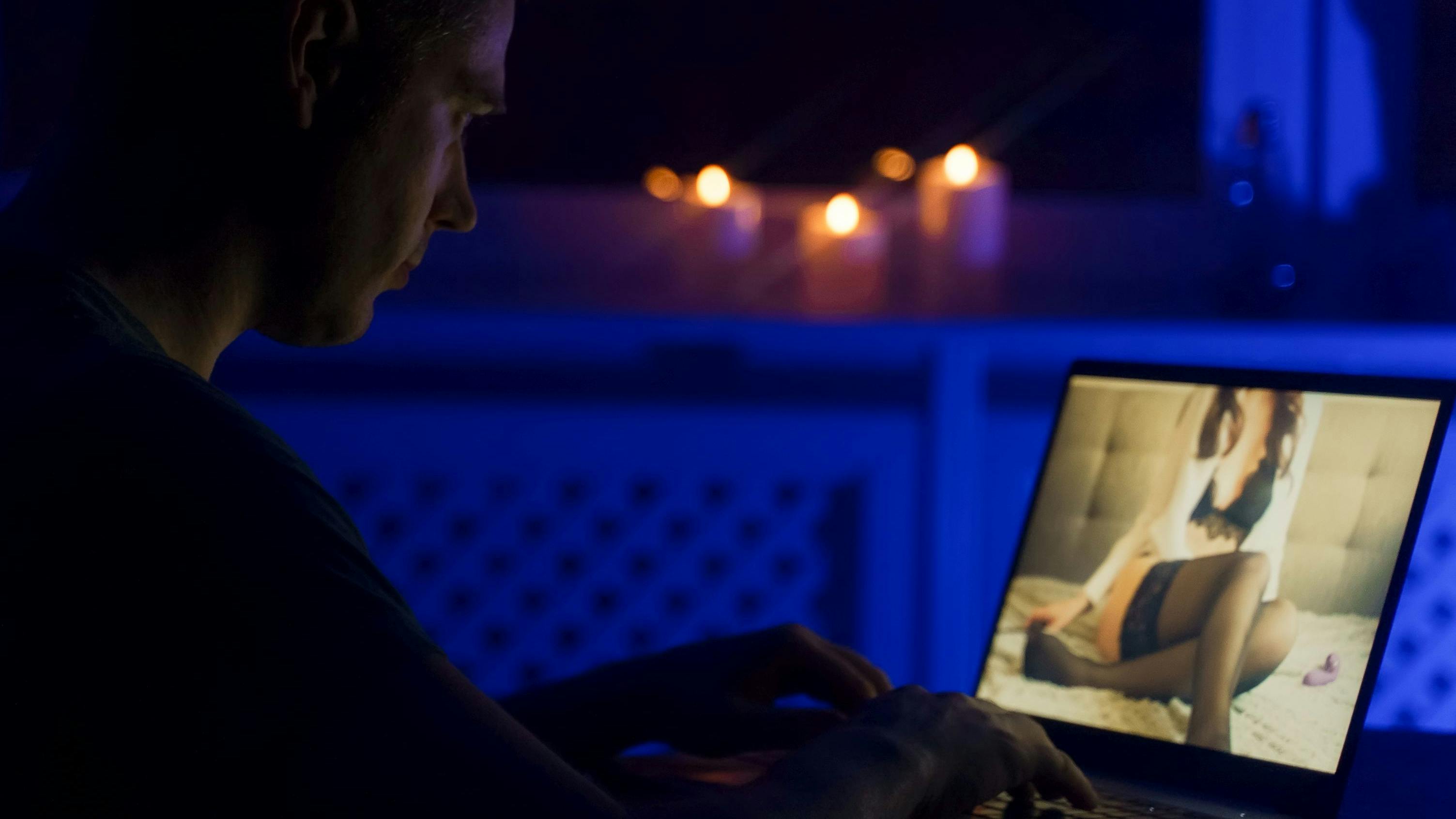 Man chatting with webcam model late at night.