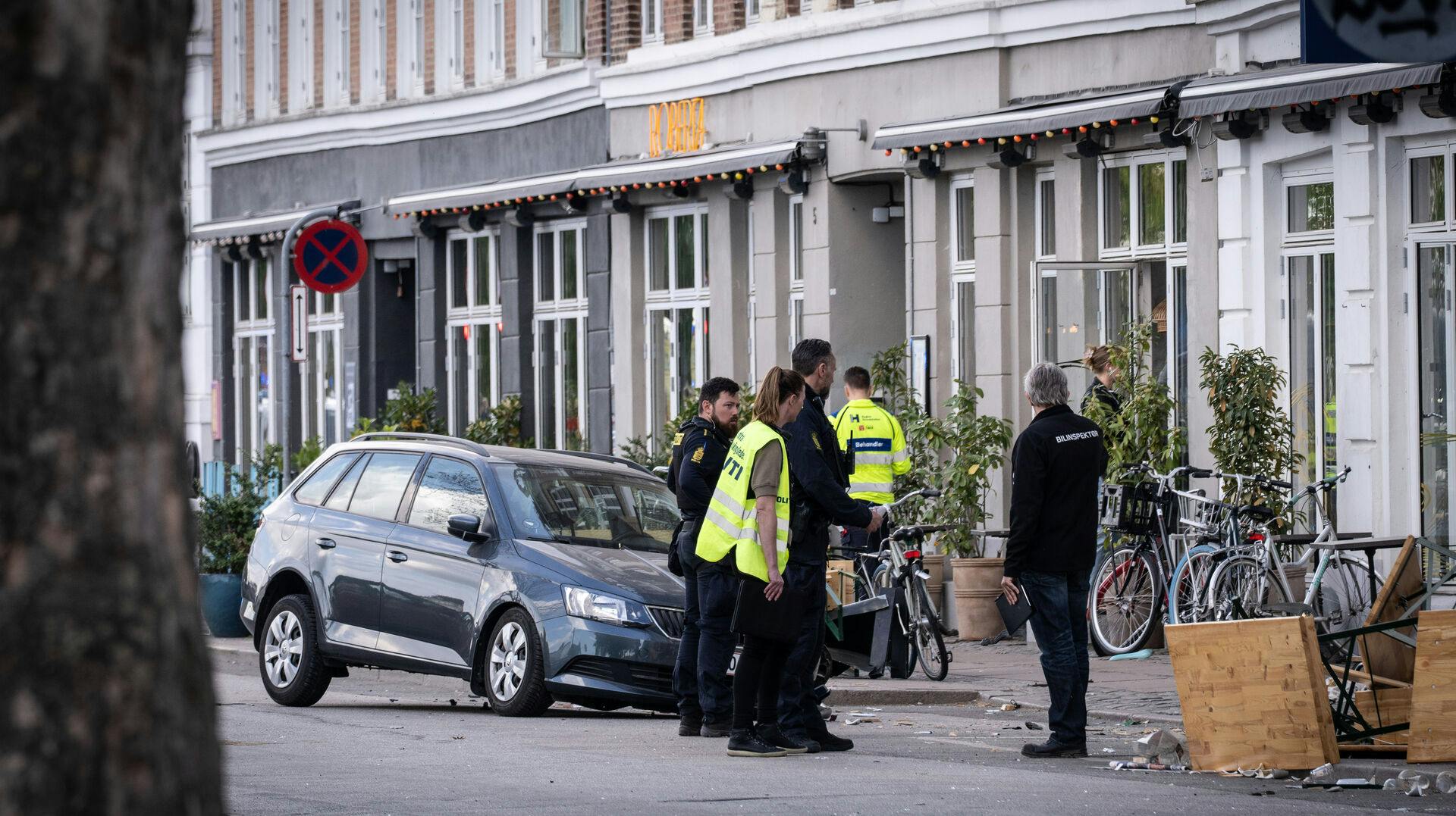 Teknikere undersøger området, hvor den ældre mand ramte en større gruppe af mennesker. Bilen på billedet er IKKE den bil, han kørte i.