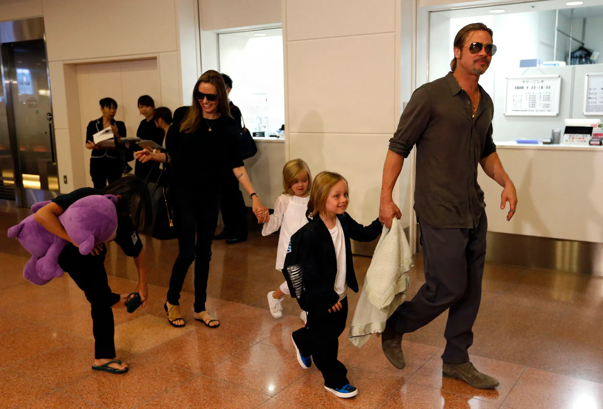 Hollywood actor Brad Pitt (R) and actress Angelina Jolie (2nd L) arrive with their children Knox (2nd R), Vivienne (3rd R) and Pax (L) at Haneda international airport in Tokyo July 28, 2013. Pitt flew into Japan on Sunday with Jolie and their children to attend promotional events of his movie "World War Z". REUTERS/Issei Kato (JAPAN - Tags: ENTERTAINMENT)