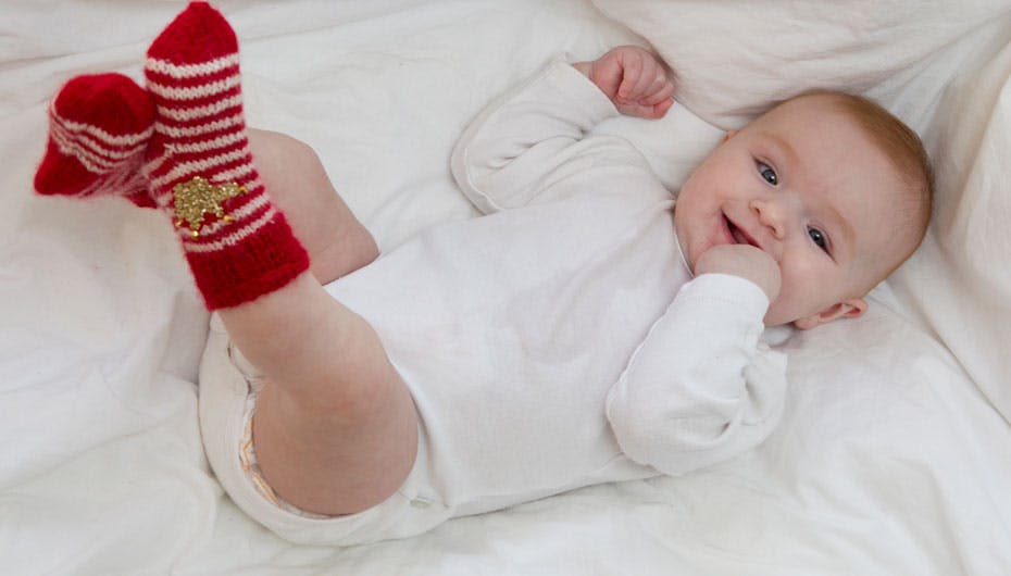 Lille Sif på seks måneder spræller glad iført de royale striksokker