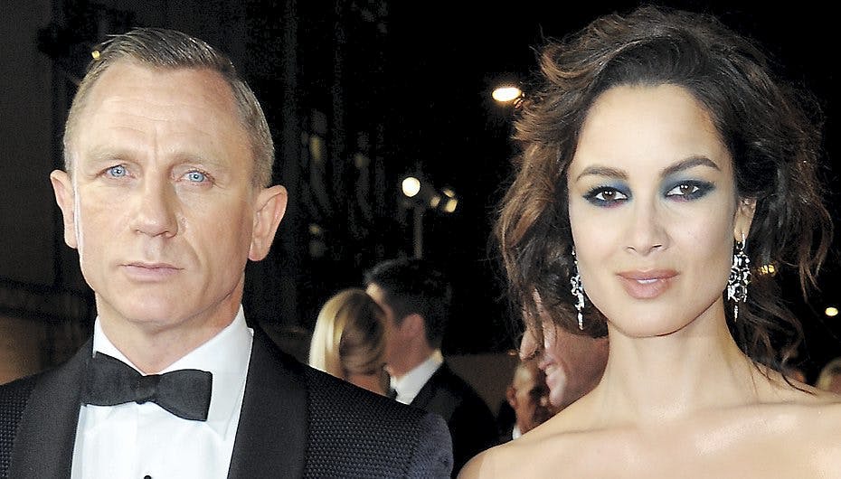 At Daniel Craig smiler stort forstår man godt med de smukke kvinder, der går ved hans side.