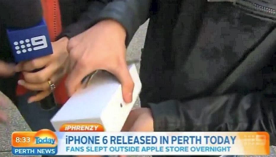 Den lykkelige unge mand pakker sin spritnye iPhone 6 ud.