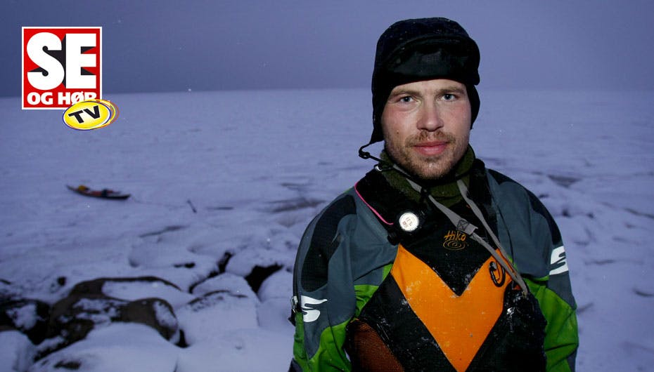 Erik B. Jørgensen stående på isen med sin kajak i baggrunden
