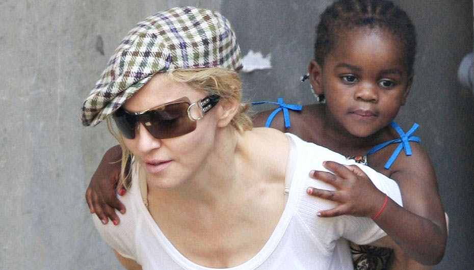 Madonna med sin lille datter på ryggen, der allerede har fået den karakteristiske røde kabbalahsnor om håndleddet