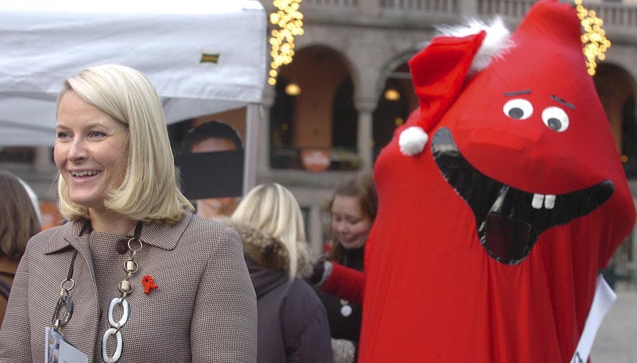 Det er svært at se, om det er Mette-Marit eller det røde kondom, der smiler mest